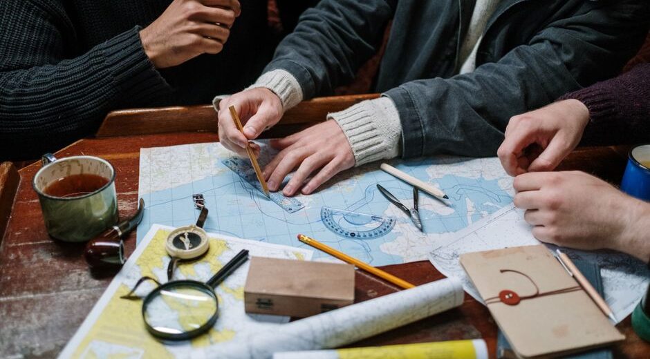 A person thoughtfully looking at a map and their phone, symbolizing flexible travel planning and adapting to changes on the go.