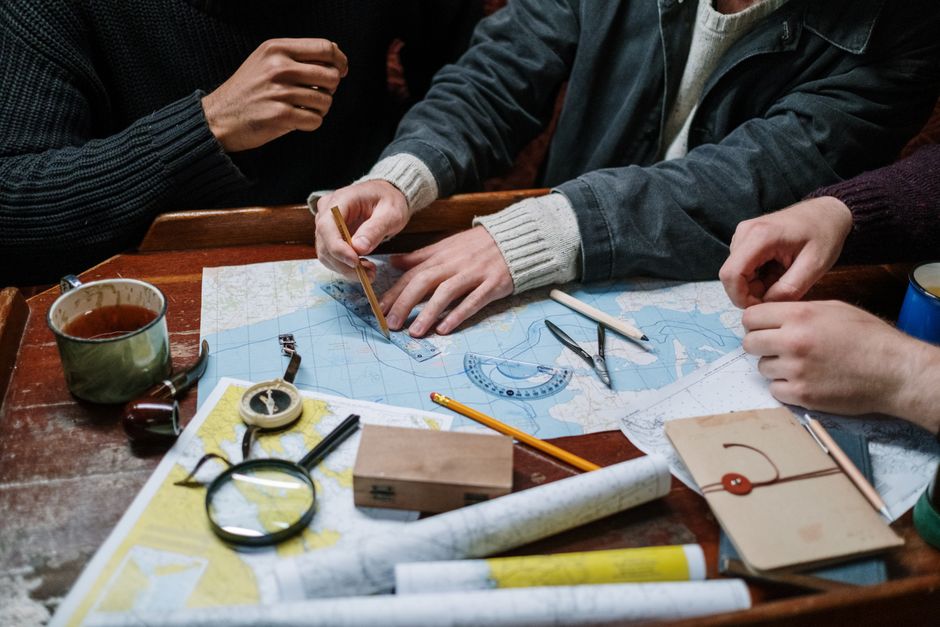 A person thoughtfully looking at a map and their phone, symbolizing flexible travel planning and adapting to changes on the go.