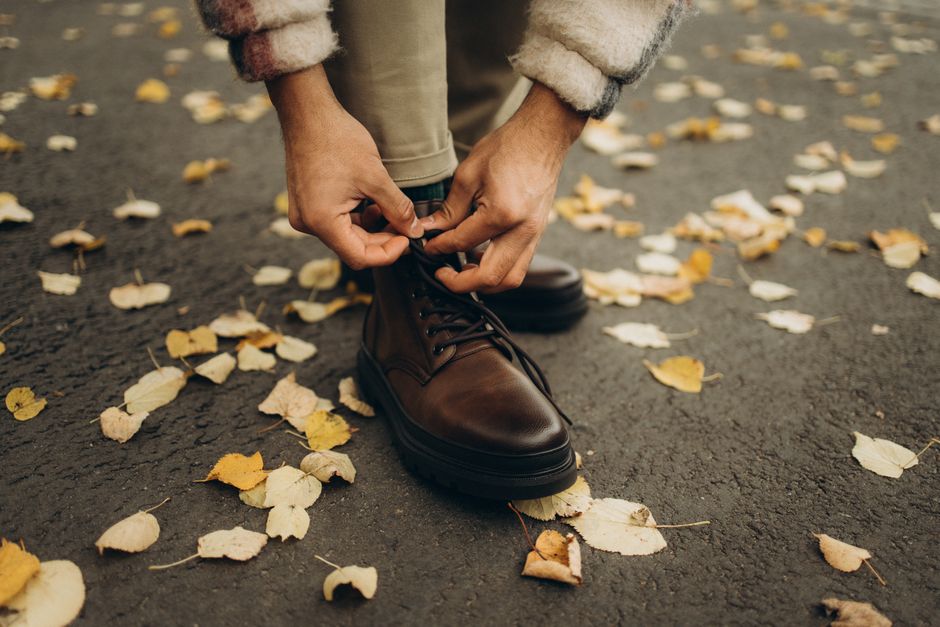 A close-up shot of a traveler adjusting the laces of a comfortable walking shoe on a sunny pavement, ready for exploration.