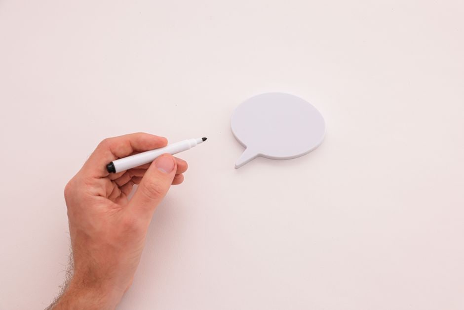 Two sets of hands wiping down a whiteboard covered in scribbled notes, representing the process of cleaning up and organizing information.