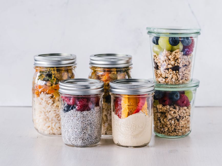 Multiple glass containers filled with different easy high-protein breakfast options, such as overnight oats and egg muffins, ready for meal prep.
