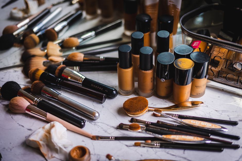 A curated selection of diverse skincare bottles and minimalist makeup items laid out on a clean surface, emphasizing a low-maintenance routine.