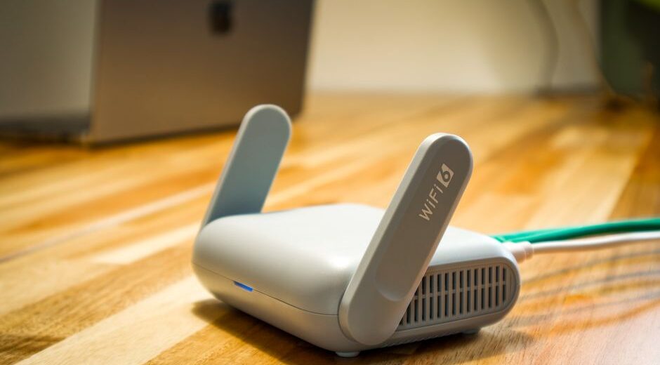 A Wi-Fi 6 router sits on a desk in a well-lit home office, connecting a laptop, tablet, and smart speaker.