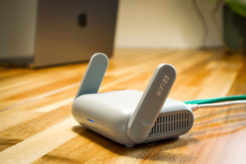 A Wi-Fi 6 router sits on a desk in a well-lit home office, connecting a laptop, tablet, and smart speaker.