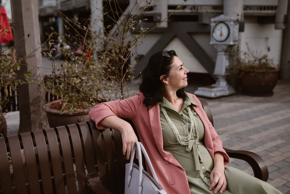 A professional woman wearing a blazer over a versatile dress in an office setting, illustrating a practical workwear outfit that can be adapted for unpredictable spring temperatures.