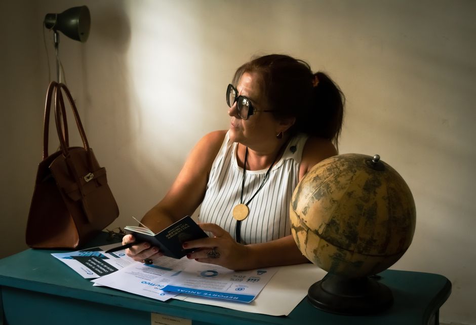 A woman using a smartphone to read hotel reviews and compare amenities for a travel destination, making an informed decision beyond just the cheapest price.