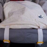 Woman working remotely in a cafe, a stylish yet practical everyday bag next to her laptop, symbolizing work-life integration.